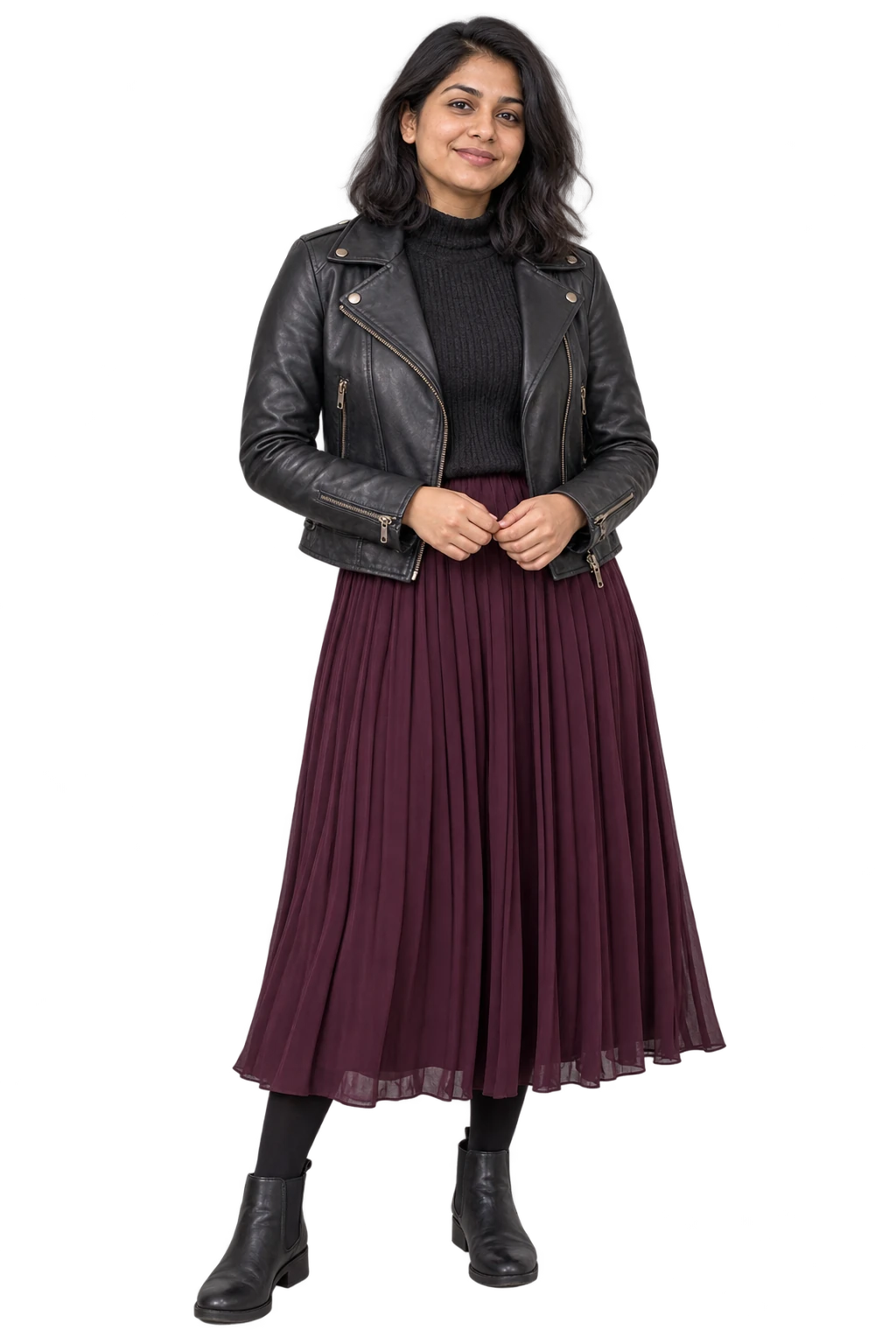 A woman wearing a charcoal biker-style jacket, high-neck knit, plum pleated midi skirt and ankle boots