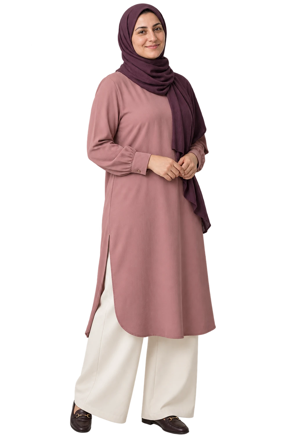 A woman in a dusty rose long tunic, ivory wide-leg trousers and a plum headscarf