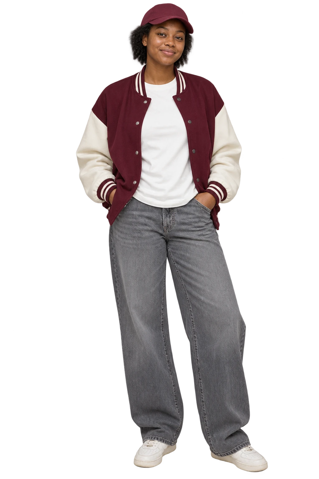 A woman in a burgundy oversized varsity-style jacket, ivory tee, wide grey jeans and trainers